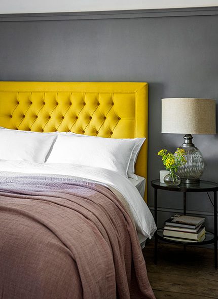 Yellow, mustard coloured fabric covered buttoned made to order Mia headboard in bedroom interior with Daphne pink throw Perch & Parrow